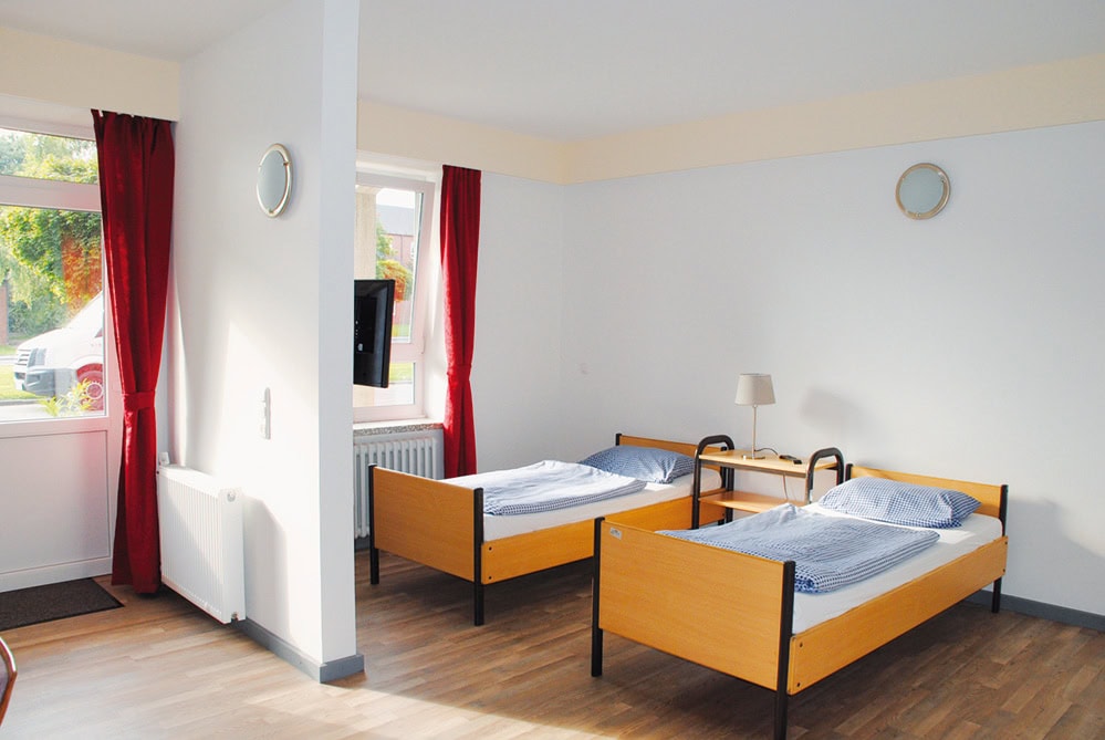 Helles Appartement mit zwei Einzelbetten, großen Fenstern und viel Tageslicht – komfortable und funktionale Unterkunft im Motel 16.